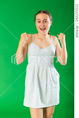 Happy teenage girl in front of green screen 142255511