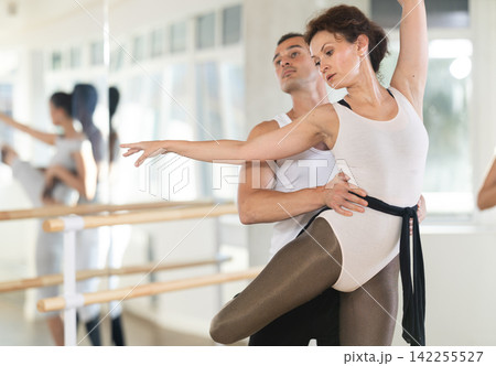 Young man and adult woman rehearsing pair ballet Young man and adult woman rehearsing pair ballet 142255527