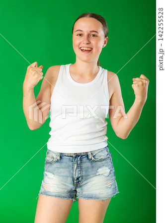 Happy teenage girl in front of green screen Happy teenage girl in front of green screen 142255528