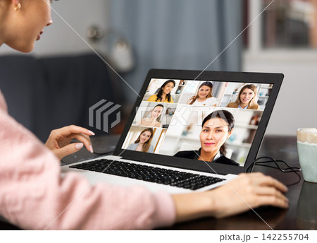 Young woman is holding a video conference on a laptop Young woman is holding a video conference on a laptop 142255704