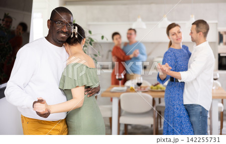 Black man enjoying slow dance with woman at house party Black man enjoying slow dance with woman at house party 142255731