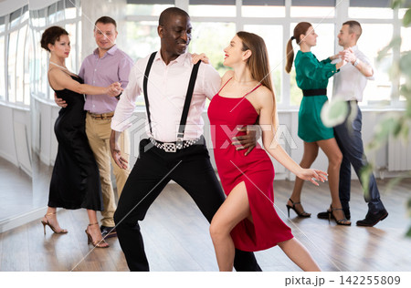 Woman with African man dancing waltz in couple during lesson at studio Woman with African man dancing waltz in couple during lesson at studio 142255809