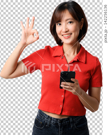 Happy smiling asian woman holding smartphone showing okay gesture wearing red shirt isolated on transparent background cutout stock photo Happy smiling asian woman holding smartphone showing okay gesture wearing red shirt isolated on transparent background cutout stock photo 142256136