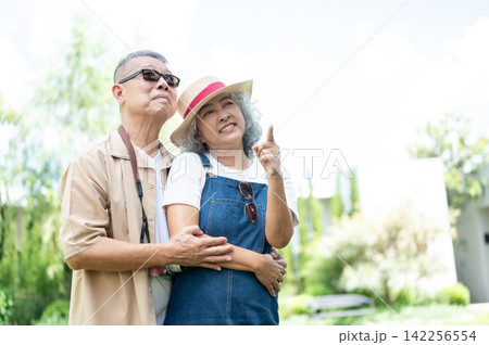 Asian senior Mature Couple Enjoying Coffee and Travel at a Cafe Asian senior Mature Couple Enjoying Coffee and Travel at a Cafe 142256554