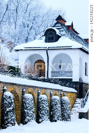 Charming European building covered in fresh snow during a serene winter season 142258225