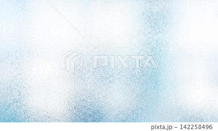 Close macro view displaying blurred frosted glass surface revealing soft light transmitting through textured transparent material creating tranquil abstract background pattern 142258496