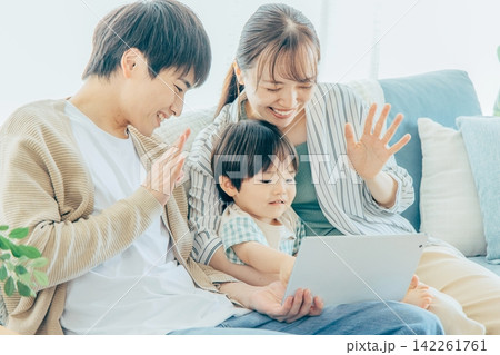 リビングでタブレットを見る家族 リビングでタブレットを見る家族 142261761