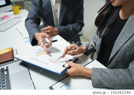 Business Team Reviewing Financial Charts in Office Business Team Reviewing Financial Charts in Office 142262140