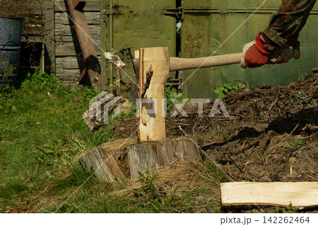 A man chops wood withan axe. Preparing fuelfor the winter A man chops wood withan axe. Preparing fuelfor the winter 142262464