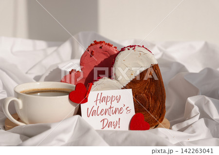 HAPPY VALENTINE'S DAY phrase lettering paper greeting card Morning breakfast in bed in wooden tray Present gift idea Holiday celebration Heart shaped croissants. Puff pastry new trendy sweet dessert 142263041