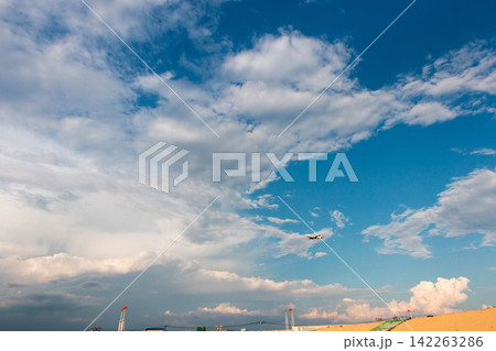 広がる青空と雲の中を飛ぶ飛行機 広がる青空と雲の中を飛ぶ飛行機 142263286