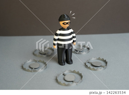 A criminal wearing a robber mask surrounded by traps. Dead end and inevitable capture. The criminal outcome is predetermined as law enforcement closes every escape route. A criminal wearing a robber mask surrounded by traps. Dead end and inevitable capture. The criminal outcome is predetermined as law enforcement closes every escape route. 142263534