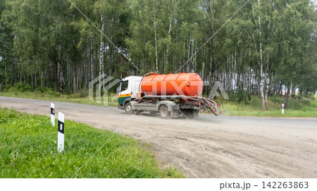 Vacuum truck for wastewater treatment.  Sewage truck turns onto the road to a farm. 142263863