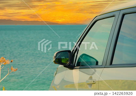 秋、夕方の海を見下ろす一台の白い国産車 秋、夕方の海を見下ろす一台の白い国産車 142263920