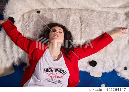 Stylish woman exhibiting trendy outfit on plush sofa for photography Stylish woman exhibiting trendy outfit on plush sofa for photography 142264147