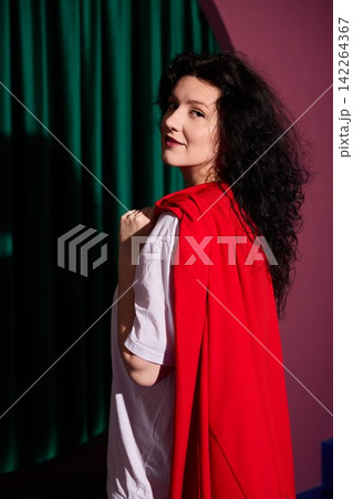 Closeup of woman wearing red cloak making eye contact gently Closeup of woman wearing red cloak making eye contact gently 142264367