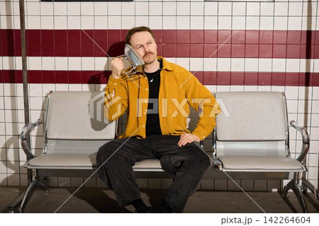 Stylish man with handset exudes relaxed urban confidence imagery 142264604