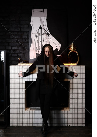 Darkly dressed performer illuminates scene with occult ambiance Darkly dressed performer illuminates scene with occult ambiance 142264614