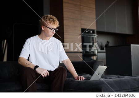 Young Caucasian male reviews spreadsheet information attentively Young Caucasian male reviews spreadsheet information attentively 142264636