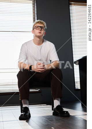 Calm and professional youth seated quietly in minimalistic environment 142264681