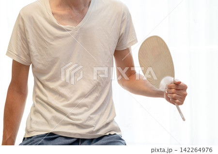 手に持ったうちわで扇ぐ男性 手に持ったうちわで扇ぐ男性 142264976