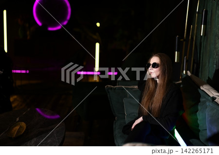 Stylish woman in sunglasses enjoys rooftop evening ambiance Stylish woman in sunglasses enjoys rooftop evening ambiance 142265171