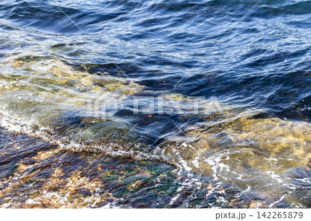 岸壁に打ち寄せる透明な波と青い海面 海岸の自然風景 岸壁に打ち寄せる透明な波と青い海面 海岸の自然風景 142265879