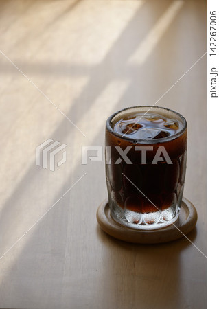 陽の射し込む窓際に置かれたアイスコーヒー 陽の射し込む窓際に置かれたアイスコーヒー 142267006