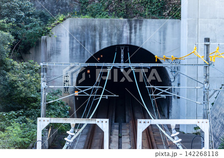 山を貫くコンクリート造りの鉄道トンネル坑口と架線柱 山を貫くコンクリート造りの鉄道トンネル坑口と架線柱 142268118