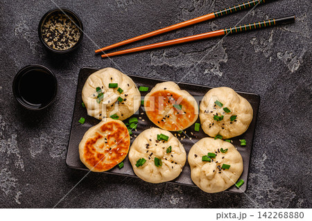 Delicious buns served on a plate with sauces and toppings 142268880