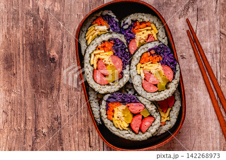 Colorful kimbap (or gimbap) with vegetables and sausage in a wooden box Colorful kimbap (or gimbap) with vegetables and sausage in a wooden box 142268973