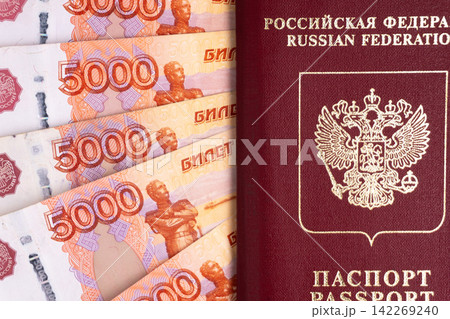 Russian passport and 5000 ruble banknotes. Federation identification document with cash money. Finance and travel concept 142269240