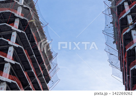Concrete high-rise buildings under construction with protective safety nets Concrete high-rise buildings under construction with protective safety nets 142269262