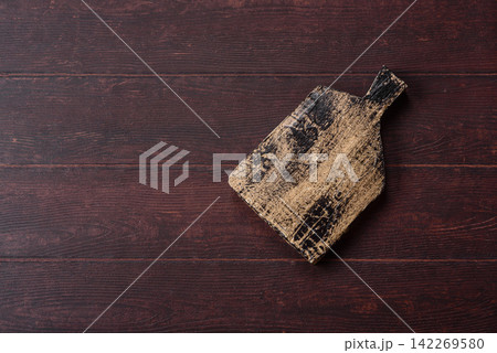 A square wooden cutting board for home food preparation. A wooden cutting board 142269580