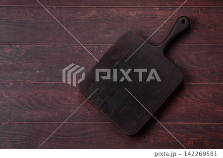 A square wooden cutting board for home food preparation. A wooden cutting board A square wooden cutting board for home food preparation. A wooden cutting board 142269581