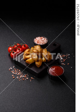 Fried potato wedges seasoned with salt and spices, ready for dinner table. Fried potato wedges 142269752