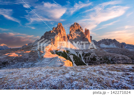 Tre Cime di Lavaredo illuminated by warm sunrise light after an early snowfall 142271024