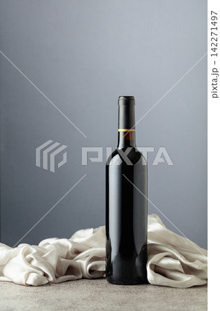 Bottle of red wine on a grey background. Bottle of red wine on a grey background. 142271497