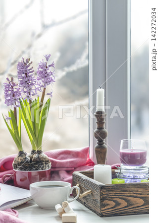 Early spring still life scene. Cup of coffee and marshmallow, opened notebook, pink plaid and candles on windowsill. Cozy Easter, vintage feminine styled photo Early spring still life scene. Cup of coffee and marshmallow, opened notebook, pink plaid and candles on windowsill. Cozy Easter, vintage feminine styled photo 142272034
