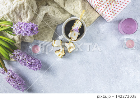 Cup of coffee with milk and delicious fried marshmallow and pink hyacinths on light concrete surface background. Top view, copy space Cup of coffee with milk and delicious fried marshmallow and pink hyacinths on light concrete surface background. Top view, copy space 142272038