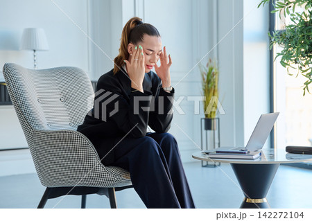 Stressed young businesswoman crying at home office with laptop computer. Stressed young businesswoman crying at home office with laptop computer. 142272104