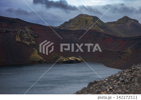 Volcanic crater lake with moss-covered mountains in Iceland Volcanic crater lake with moss-covered mountains in Iceland 142272511