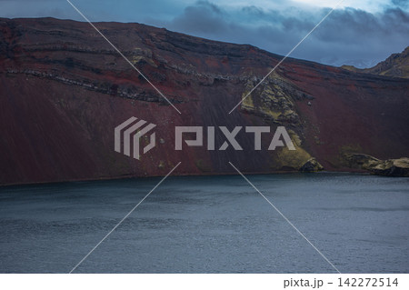 Red volcanic crater lake in Iceland with dramatic mountain cliffs Red volcanic crater lake in Iceland with dramatic mountain cliffs 142272514
