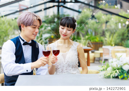 水上テラスでワインを飲む新郎新婦 水上テラスでワインを飲む新郎新婦 142272901