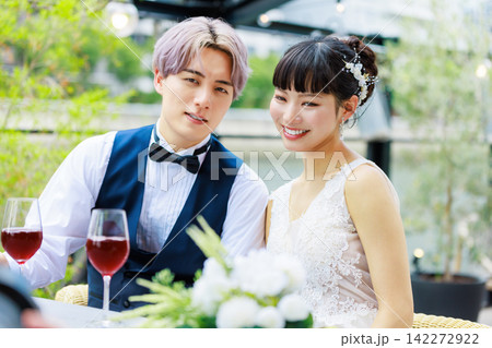 水上テラスでワインを飲む新郎新婦   142272922