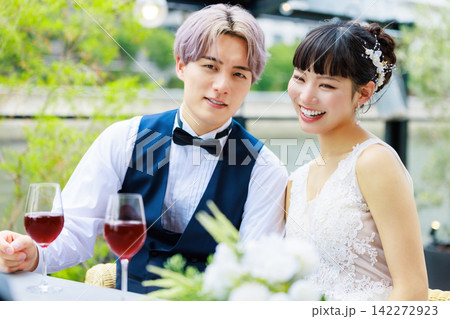 水上テラスでワインを飲む新郎新婦 水上テラスでワインを飲む新郎新婦 142272923
