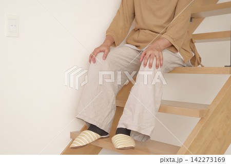 階段の上り下りで膝に痛みを感じる女性 階段の上り下りで膝に痛みを感じる女性 142273169