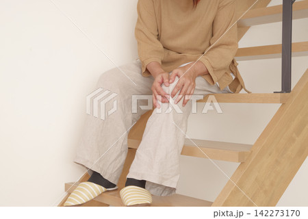 階段の上り下りで膝に痛みを感じる女性 階段の上り下りで膝に痛みを感じる女性 142273170