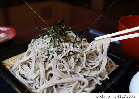 大盛りのざるそば。十割そば。海苔トッピング。黒い竹ざる。 142273675