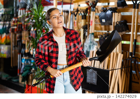 Female farmer choosing shovel in gardening store 142274029